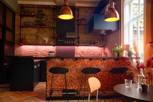 een keuken met een bar met stoelen en een tafel bij Boetiek hotel Azul in Goedereede