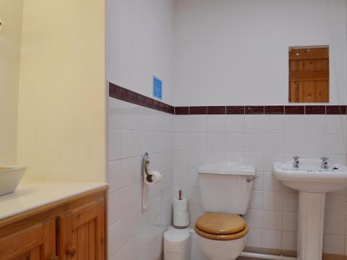 a bathroom with a toilet and a sink at Barn Owl Cottage in Cromford