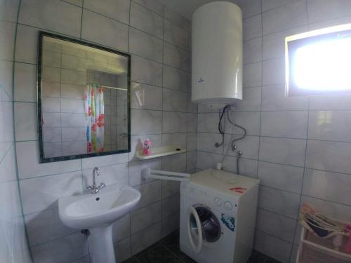 La salle de bains est pourvue d'un lavabo et d'un lave-linge. dans l'établissement Vitorlás villa földszint, à Balatonlelle