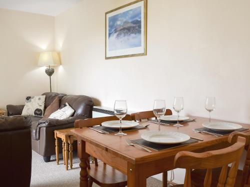 a living room with a wooden table with wine glasses at West View in Bowness-on-Windermere