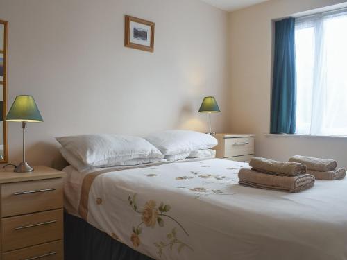 a bedroom with a large bed with towels on it at West View in Bowness-on-Windermere