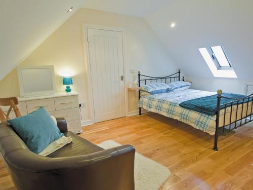 um quarto com uma cama e um sofá num quarto em Dairy Cottage - E5279 em Shincliffe