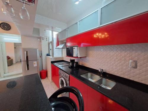 una cocina con armarios rojos y fregadero en Departamento de Lujo en la Ciudad Buenos Aires en Buenos Aires