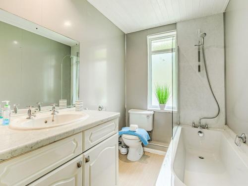 a bathroom with a sink and a toilet and a tub at West Brae in Bishops Tawton