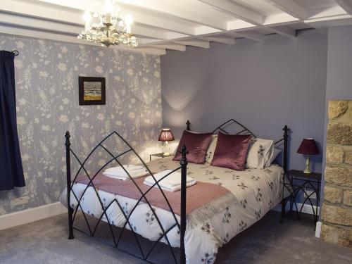 a bedroom with a bed and a chandelier at Gable End Cottage in Goathland