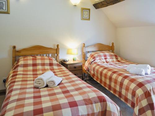Dos camas en una habitación con toallas. en The Granary - E4753, en Ebrington
