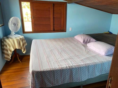 プラドにあるCasa com piscina e um quarto com ar split pé na areia a 50 metros da praiaのベッドルーム1室(ファン、窓付)
