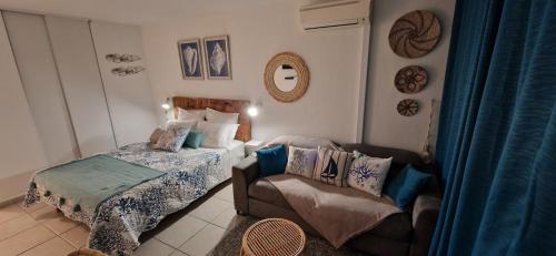 - une petite chambre avec un lit et un canapé dans l'établissement Studio Cosy, Accès Plage, au Gosier