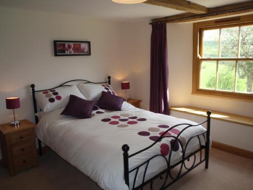 a bedroom with a large bed with purple pillows at Gateside Farmhouse Sedbergh in Sedbergh