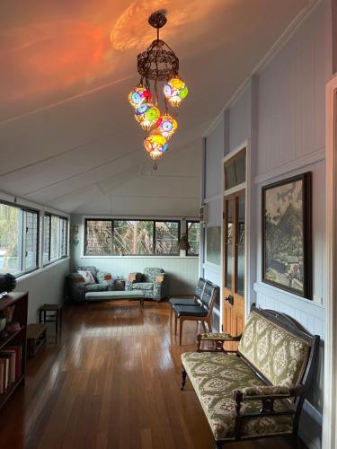 sala de estar con sofá y lámpara de araña en Chesson Lodge, en Uki