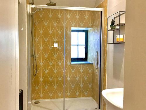 La salle de bains est pourvue d'une douche avec une porte en verre. dans l'établissement The Stables At Daubeneys, à Colerne