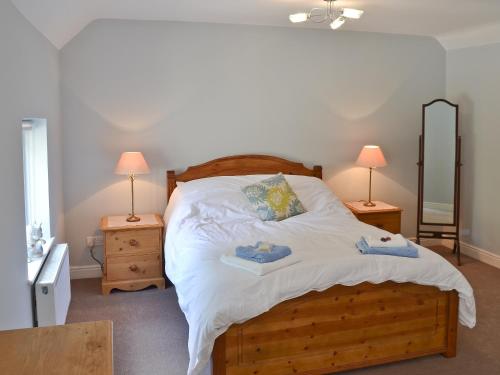 a bedroom with a wooden bed with towels on it at The Old Vicarage in Curbar