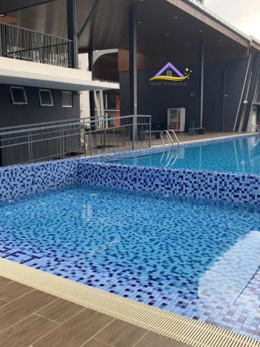 a large swimming pool with blue tiles on the side of a building at Adelia Wonderstay in Kajang