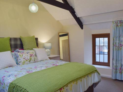 Un dormitorio con una cama verde y una ventana en Ty Capel Seion, en Cardigan