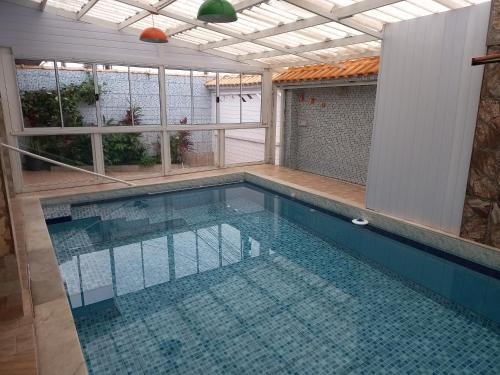 a swimming pool in a house with a swimming pool at Maranata Casa com Piscina - 2 minutos de carro até o mar in Peruíbe