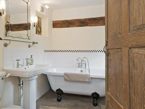 a bathroom with a white tub and a sink at Old Hall Farm House in Saint James