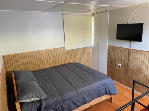 1 dormitorio con 1 cama y TV de pantalla plana en Hostal New Do Rio, en Maitencillo