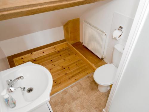 a bathroom with a white sink and a toilet at The Stable in Foxham