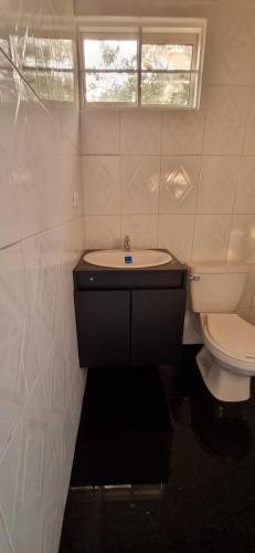 a bathroom with a toilet and a sink and a window at Apartaestudio de paso aeropuerto in Girón