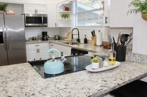 a kitchen counter with a sink and a refrigerator at 3 Bedroom Modern Ybor City Home- Pet Friendly in Tampa