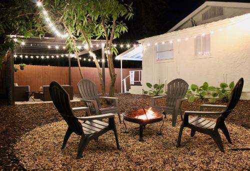 un grupo de sillas y una hoguera en un patio por la noche en 3 Bedroom Modern Ybor City Home- Pet Friendly en Tampa