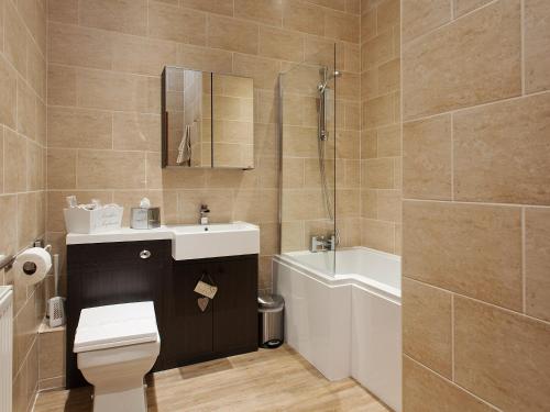 a bathroom with a toilet and a sink and a shower at Two The Old Stables in Knitsley