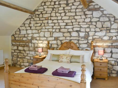 BemptonにあるPuffin Cottageの石壁のベッドルーム(ベッド付)