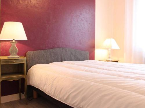 - une chambre avec un lit et un mur rouge dans l'établissement Appartement La Rochelle, 2 pièces, 4 personnes - FR-1-246-301, à La Rochelle