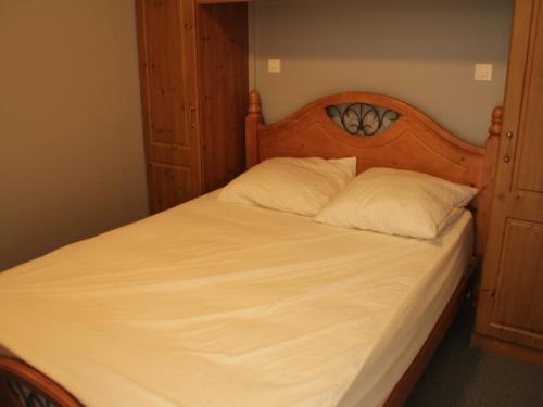 シャテルにあるStudio Châtel, 1 pièce, 2 personnes - FR-1-200-236のベッド1台(木製ヘッドボード、白い枕2つ付)