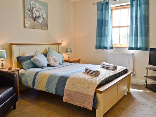 a bedroom with a bed with blue curtains at Llanlliwe Cottage in Henllan Amgoed