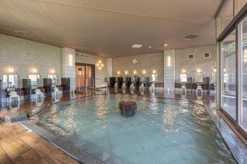 una gran piscina en el vestíbulo del hotel con sillas en KAMENOI HOTEL Toba en Toba