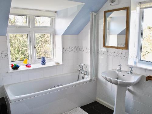a white bathroom with a tub and a sink at Castle View in Wykeham
