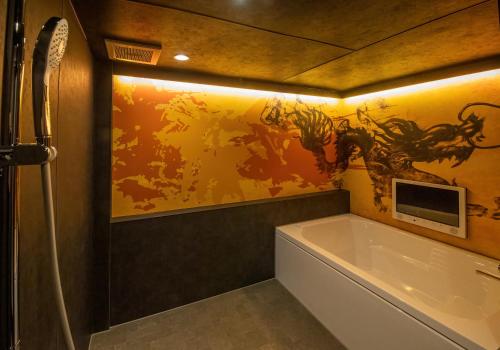 een badkamer met een bad en een schilderij aan de muur bij Hotel Kaguya in Himeji