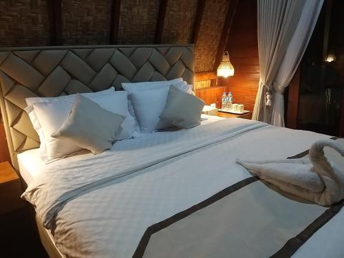 a bedroom with a large bed with a swan on it at Pavilla Labuan Bajo in Labuan Bajo