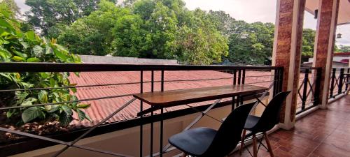 a balcony with a wooden table and two chairs at Ginto Residence - City Center in Coron