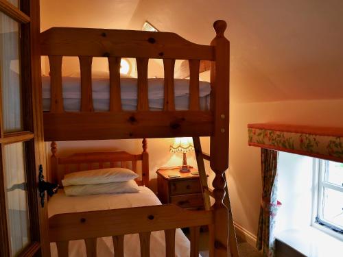 AkeldにあるTimberwick Green-medのベッドルーム1室(二段ベッド2台、テーブルの上にランプ付)
