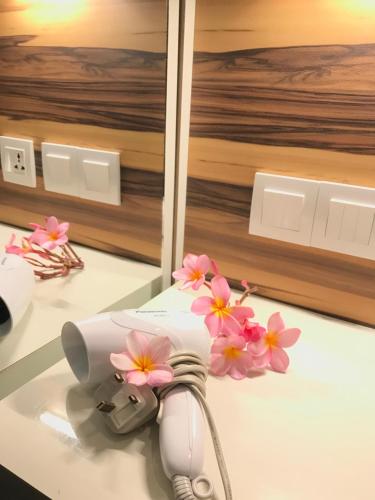 a white appliance with pink flowers on a counter at Villa Abadi Resort in Pantai Cenang