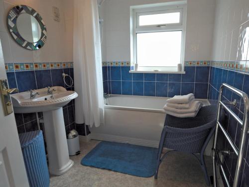 La salle de bains est pourvue d'une baignoire, d'un lavabo et d'un miroir. dans l'établissement Ty Clyd - Hw7657, à Walton East