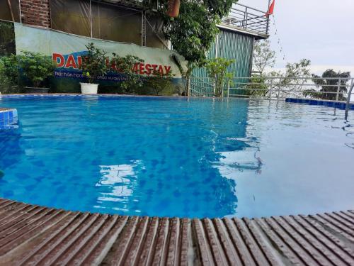 a swimming pool in a building with blue water at Daisy Homestay Tam Dao - Venuestay in Vĩnh Phúc