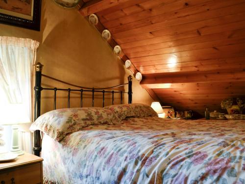 um quarto com uma cama e um tecto em madeira em Chapel Cottage em Pont Sticill