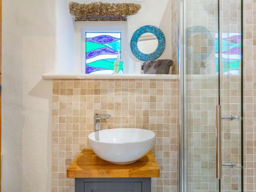 een badkamer met een wastafel en een glazen douche bij Curlews in Newlyn