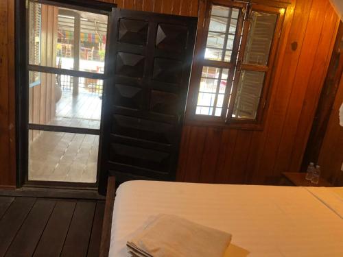 1 dormitorio con 1 cama y puerta con ventana en Nomad Guesthouse, en Kratié