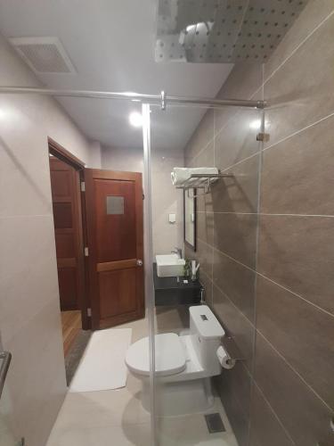 a bathroom with a toilet and a glass door at Happy Home in Nha Trang
