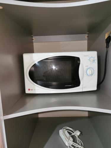a microwave sitting on top of a shelf at 2 комн квартира в центре по Пушкина in Kostanay