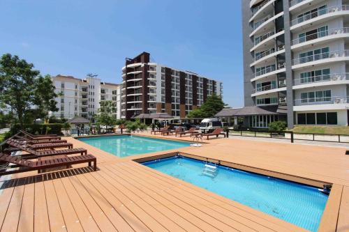 a swimming pool with lounge chairs and a building at The Leisure Hotel in Bang Bo