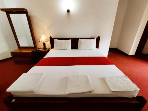 a bedroom with a large bed with a red floor at Kreation Hotels Colombo in Colombo
