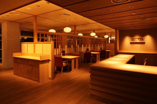 a restaurant with tables and chairs and lights at KAMENOI HOTEL Toba in Toba