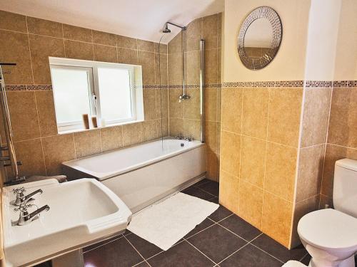 y baño con bañera, aseo y lavamanos. en Dol Llan - Hw7569, en Llangrannog