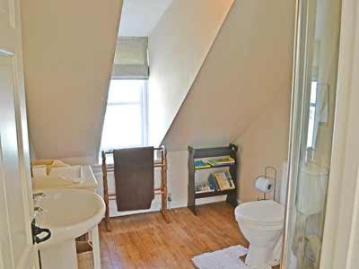 uma casa de banho com um lavatório, um WC e uma escada. em Wherry Cottage em Wells next the Sea