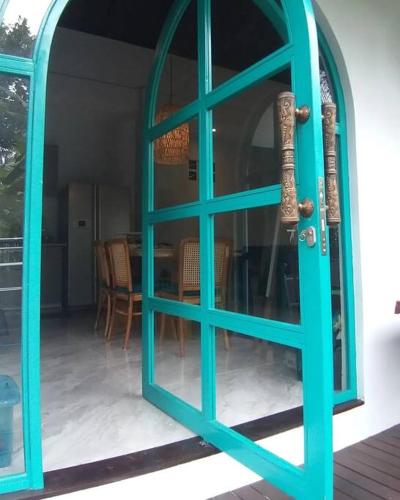 a blue door to a room with a table at casa idea ubud in Ubud